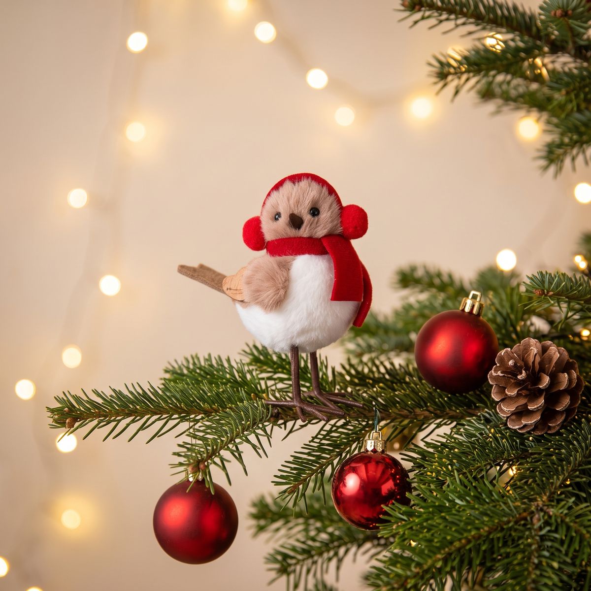 Weihnachtsvogel mit Ohrenschützern auf einem Tannenzweig